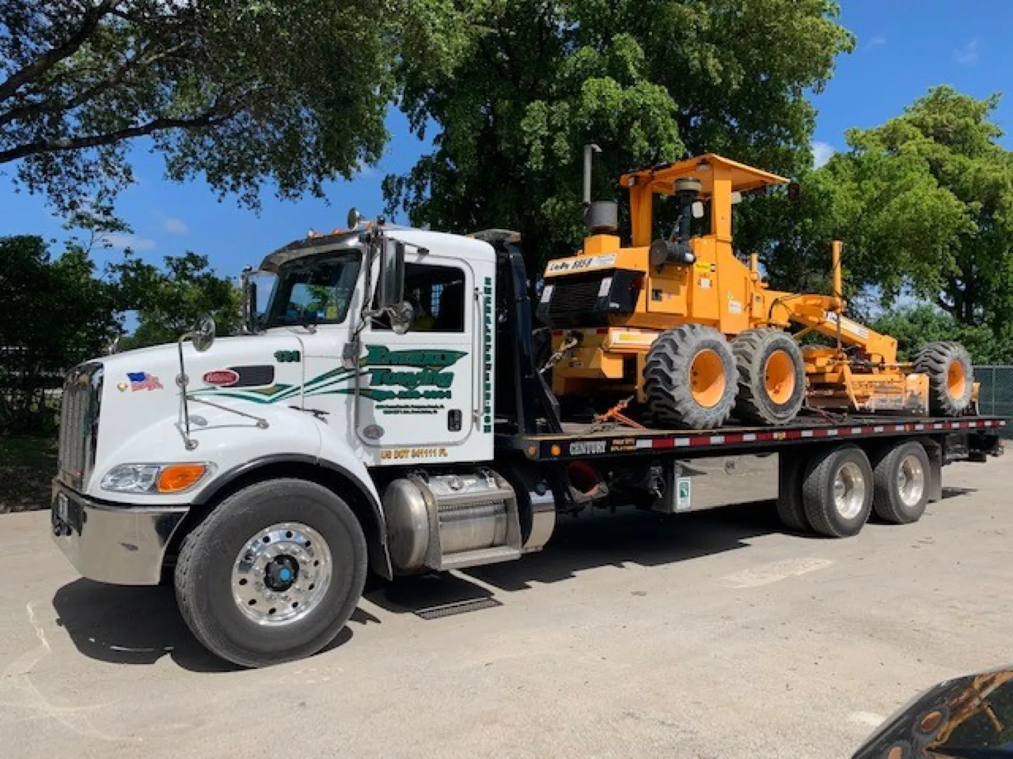 Services-Flat-Bed-Transportation Emerald Transportation truck hauling heavy machinery